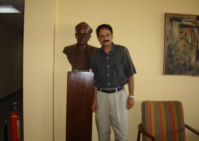 Professor Misra with a bust of Sir C.V. Raman in the 4th floor hallway of TIFR, Mumbai, India